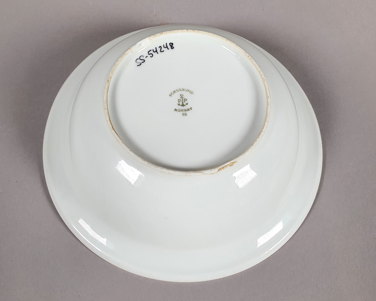 Hvit dyp tallerken av porselen, med grønt bladmønster langs kanten.