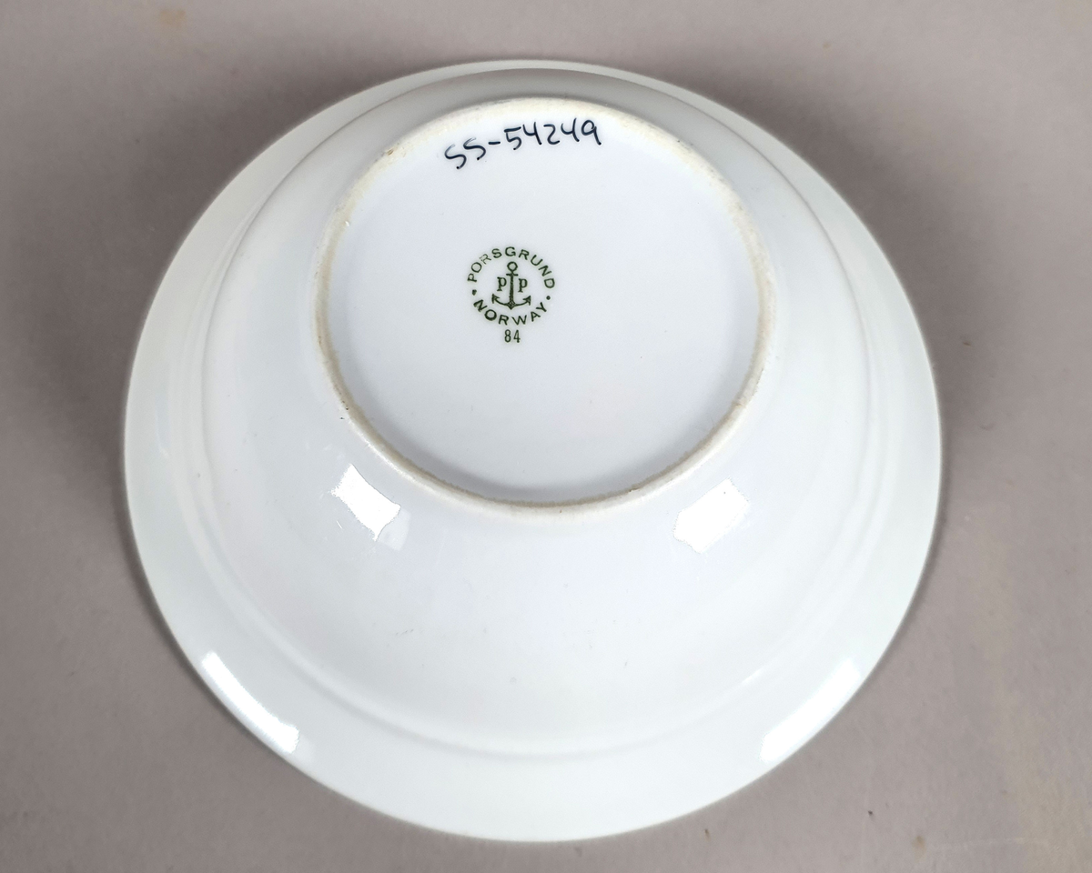 Hvit dyp tallerken av porselen, med grønt bladmønster langs kanten, og turistforeningens logo fra perioden 1943-1987.