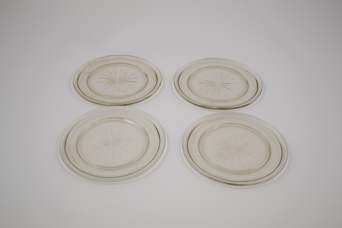 13 stk. runde glass fat av 5 ulike typer. To typer glassasjetter: 2 stk. med fasetter som minner om kronblader og bølgete kant, 4 stk. rette med forhøyet kant ytterst. Tre typer glasskåler: 1 stk. med fasetter som minner om kronblader og bølgete kant. 3 stk. med fasetter i bunnen, men rett kant, 1 stk. med kløverdekor i bunnen og rett kant. En type glassbolle med fasetter som minner om kronblader og bølgete kant.