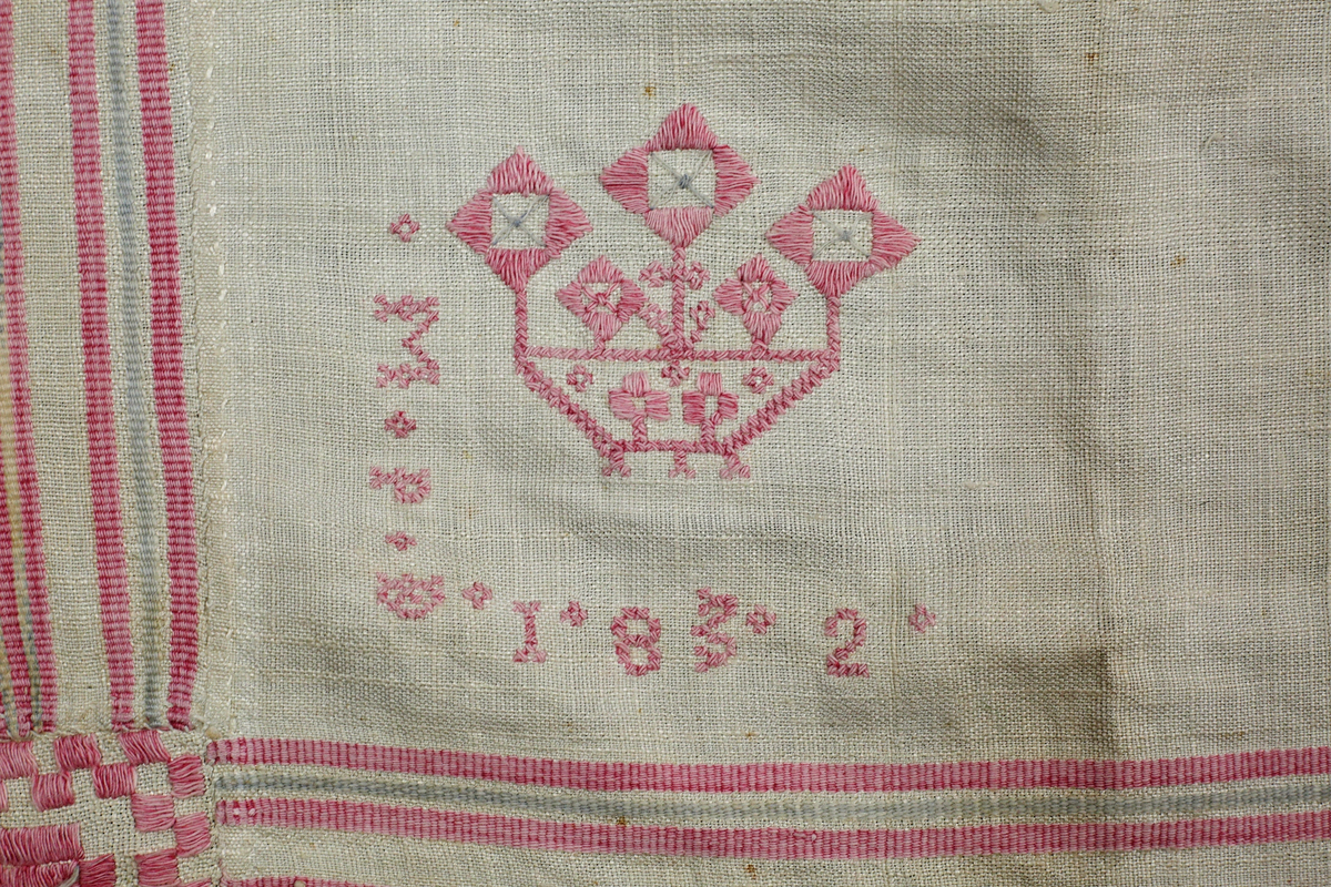 Kvadratiskt halskläde av hellinne. Bård i inslagsrips. Broderi i nedre vänstra hörnet och märkt MPD 1832. Insydd ruta i nedre vänstra hörnet. Broderier i rätlinjig plattsöm och korssöm.