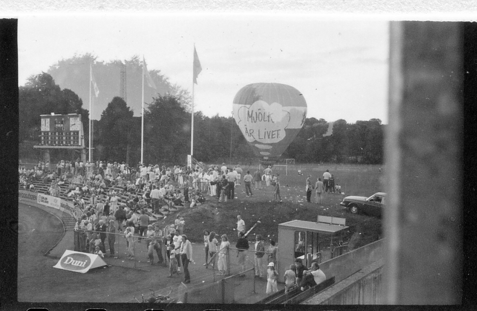 Halmstad, Örjans vall. Prestigederbyt "bäst i stan"- HBK mot Halmia, 18 juli 1984. Foto 1 och 2 (14A-15A) Arla bjöd på gräddtårta. Foto 3, 4 och 5 (16A-18A) Helikopter släppte ner bollar till barnen. Foto 6, 7, 8, 9, 10 (19A-23A) Helikopter släppte ner bollar till barnen. Foto 11 och 12 (24A-25A) Helikopter släppte bollar till barnen. Foto 13, 14 och 15 (26A-28A) Arla luftballong. Foto 16 och 17 (30A-31A) Arla Jet delade ut plastpåsar med reklam.