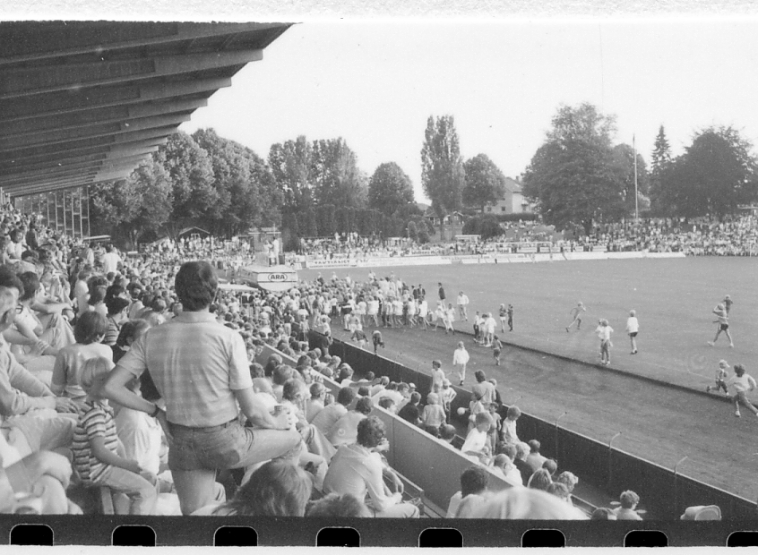 Halmstad, Örjans vall. Prestigederbyt "bäst i stan"- HBK mot Halmia, 18 juli 1984. Foto 1 och 2 (14A-15A) Arla bjöd på gräddtårta. Foto 3, 4 och 5 (16A-18A) Helikopter släppte ner bollar till barnen. Foto 6, 7, 8, 9, 10 (19A-23A) Helikopter släppte ner bollar till barnen. Foto 11 och 12 (24A-25A) Helikopter släppte bollar till barnen. Foto 13, 14 och 15 (26A-28A) Arla luftballong. Foto 16 och 17 (30A-31A) Arla Jet delade ut plastpåsar med reklam.