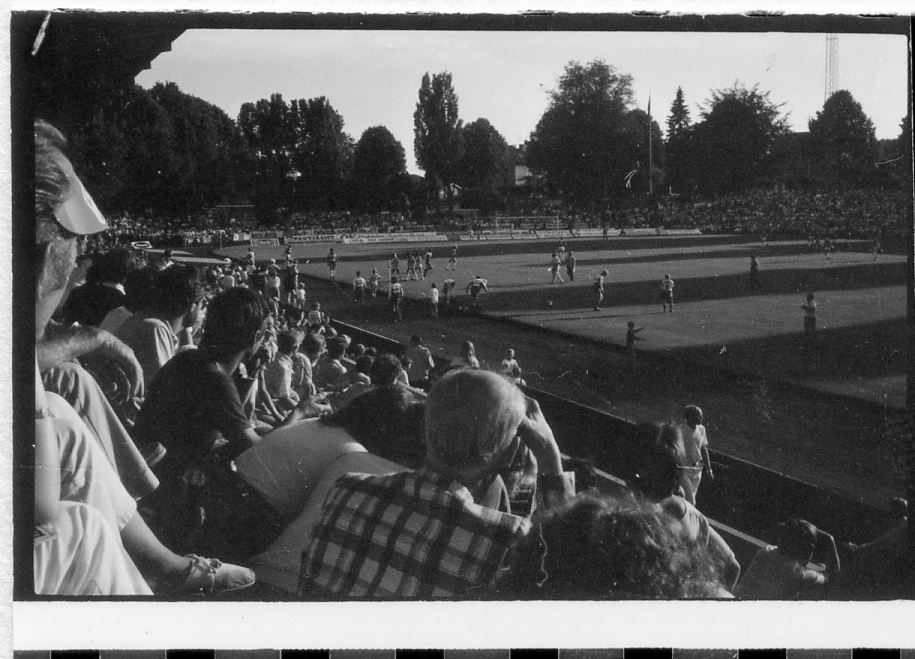 Halmstad, Örjans vall. Prestigederbyt "bäst i stan"- HBK mot Halmia, 18 juli 1984. Foto 1 och 2 (14A-15A) Arla bjöd på gräddtårta. Foto 3, 4 och 5 (16A-18A) Helikopter släppte ner bollar till barnen. Foto 6, 7, 8, 9, 10 (19A-23A) Helikopter släppte ner bollar till barnen. Foto 11 och 12 (24A-25A) Helikopter släppte bollar till barnen. Foto 13, 14 och 15 (26A-28A) Arla luftballong. Foto 16 och 17 (30A-31A) Arla Jet delade ut plastpåsar med reklam.