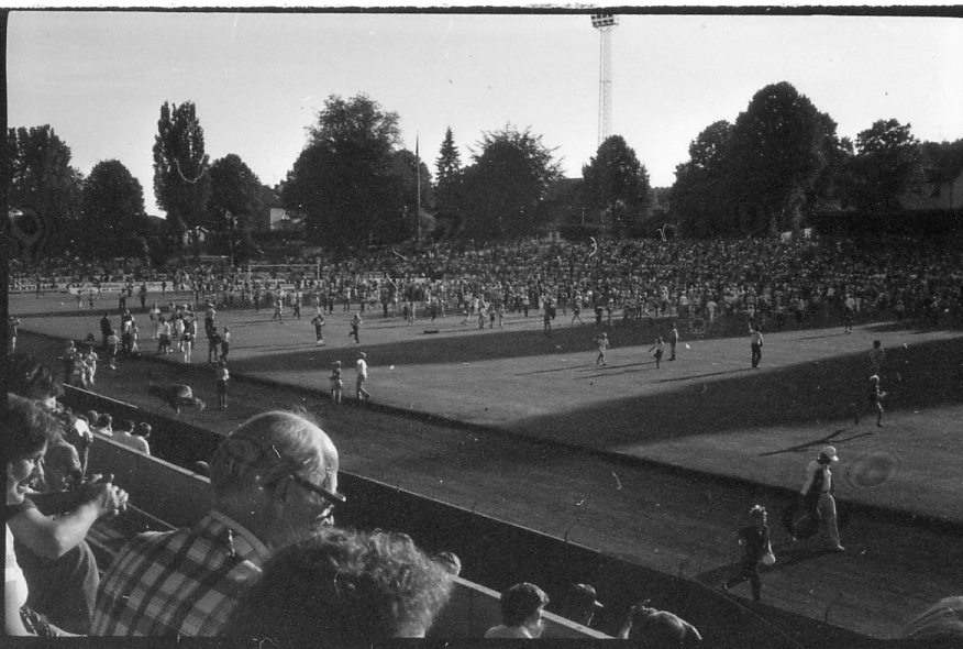 Halmstad, Örjans vall. Prestigederbyt "bäst i stan"- HBK mot Halmia, 18 juli 1984. Foto 1 och 2 (14A-15A) Arla bjöd på gräddtårta. Foto 3, 4 och 5 (16A-18A) Helikopter släppte ner bollar till barnen. Foto 6, 7, 8, 9, 10 (19A-23A) Helikopter släppte ner bollar till barnen. Foto 11 och 12 (24A-25A) Helikopter släppte bollar till barnen. Foto 13, 14 och 15 (26A-28A) Arla luftballong. Foto 16 och 17 (30A-31A) Arla Jet delade ut plastpåsar med reklam.