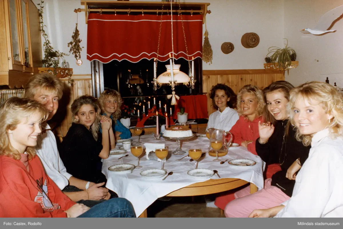 Mölndals Lucia och luciatärnorna sitter kring ett matsalsbord, december 1985.