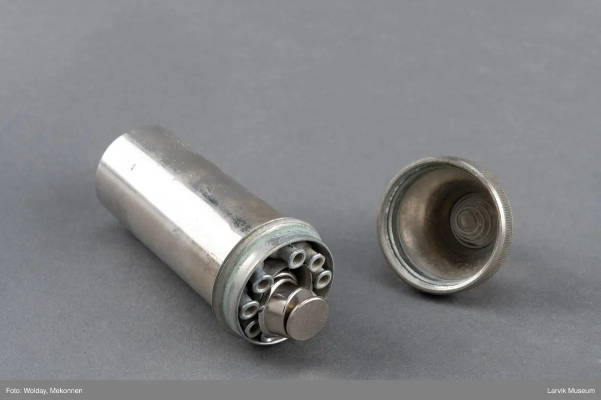En beholder i metall med sprøytespisser.