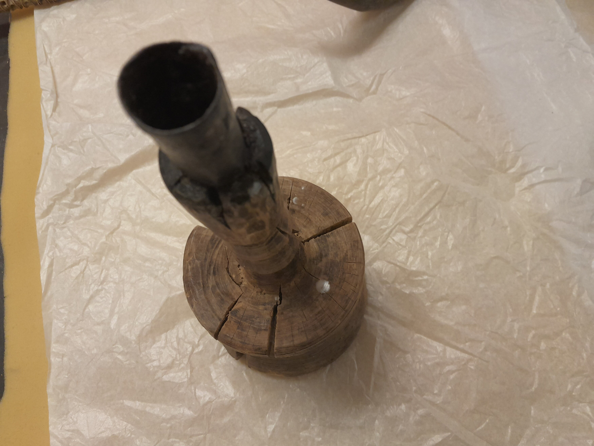 Form: Lysestake av tre med jarnpipe. Massingfasong med massiv "kvelva" fot og brei skål.

