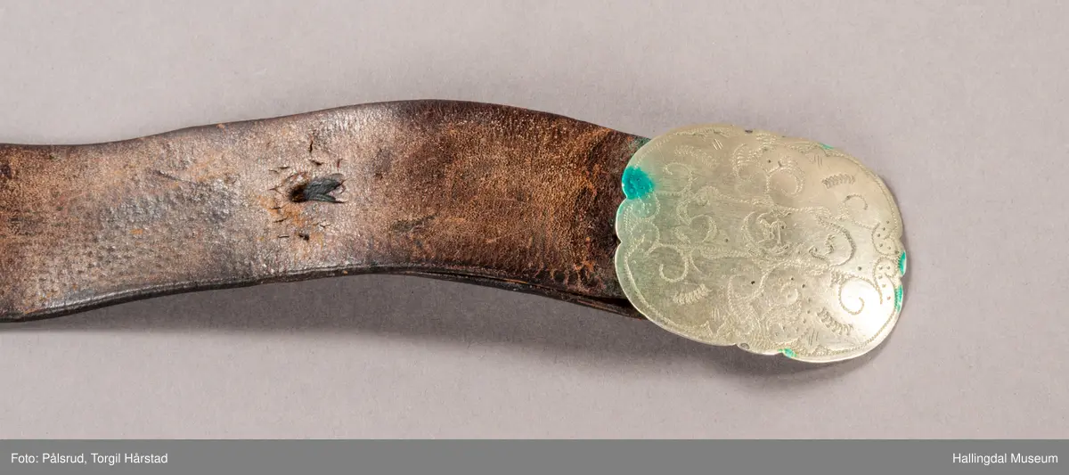 Skinnbelte med beltespenne. Gravert på beltespennen: "S.E.D."