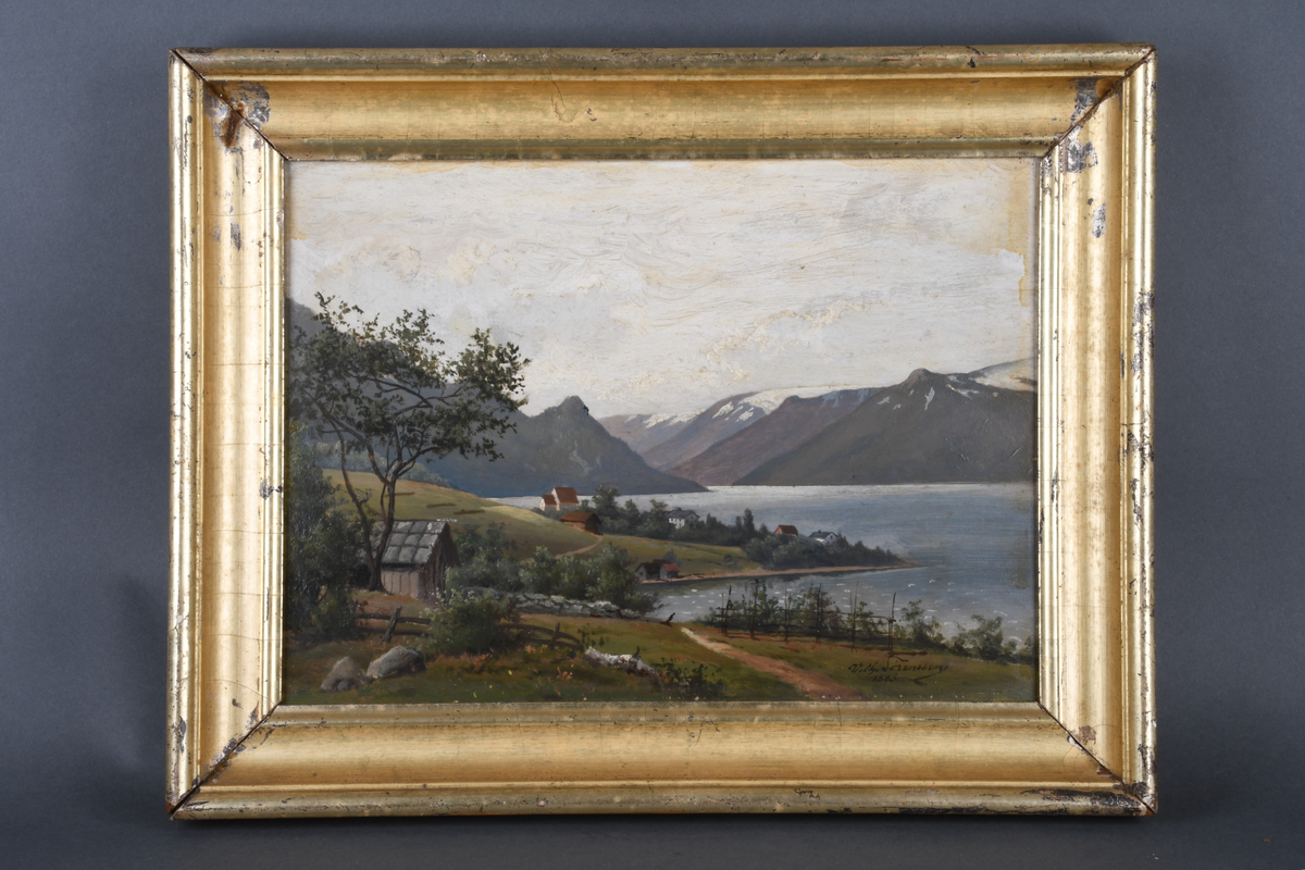 Fjordlandskap i Ullensvang kommune i Hardanger i Vestland. Sikt ut mot fjordarmen fra høyet utsiktpunkt. På flat slette ned mot fjorden ligger den hvite Kinsarvik steinkirken, noen få hus og båthus. Fjellkjede med Folgefonna isbre i bakgrunnen.