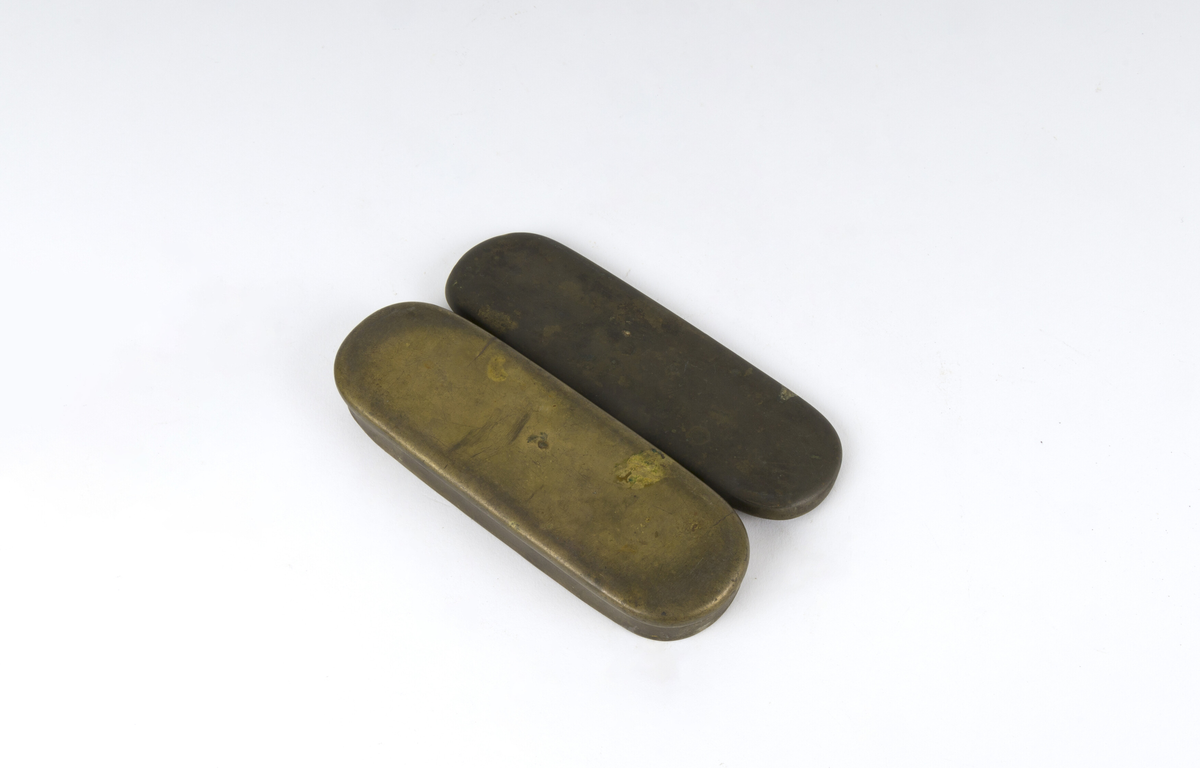 Dåse, tobakksdåse. Avlang oval snusdåse av messing med avrundede hjørner. Har en påsatt og påklinket utenpåliggende bunn og utenpåliggende, hengslet lokk.