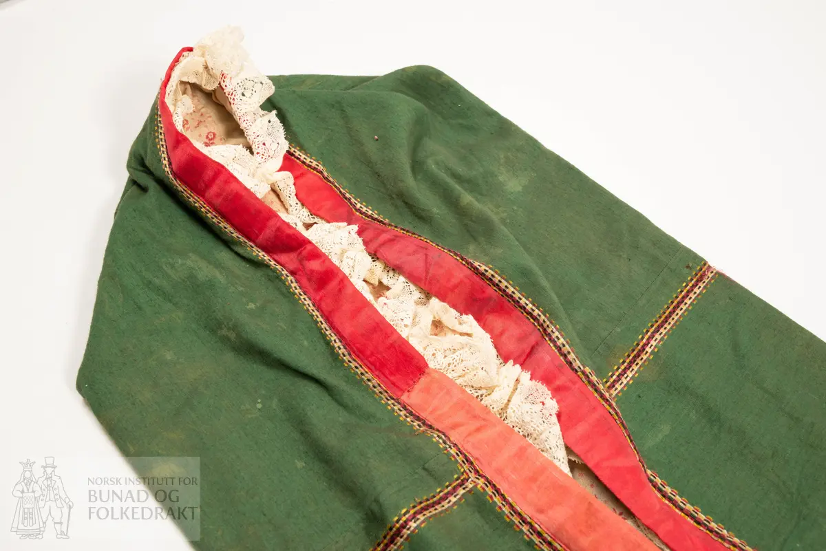 Dåpspose sydd av grøn bomullssateng. Truleg sydd av eit tørkle (?)
Stripemønster i kjerongtann, i silkekvalitet. Mf nede er infelt eit brodert parti sydd med laustvinna silketrådar i mange fargar. Heilfora av to ulike trykte bomullslerret. Påsydd ulike dekorband. Posen lukka i nedkant. Øvre kant sydd saman, og forma som ei stor posehette, med dekorknapp midt i rynketopp.