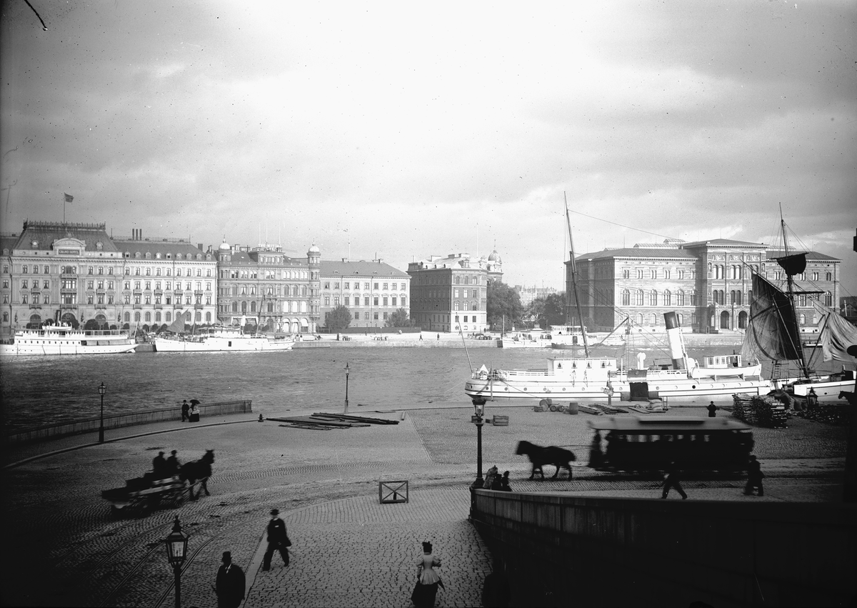 Drottning Victorias bilder. Vy över Grand Hôtel och Nationalmuseum från Skeppsbron.