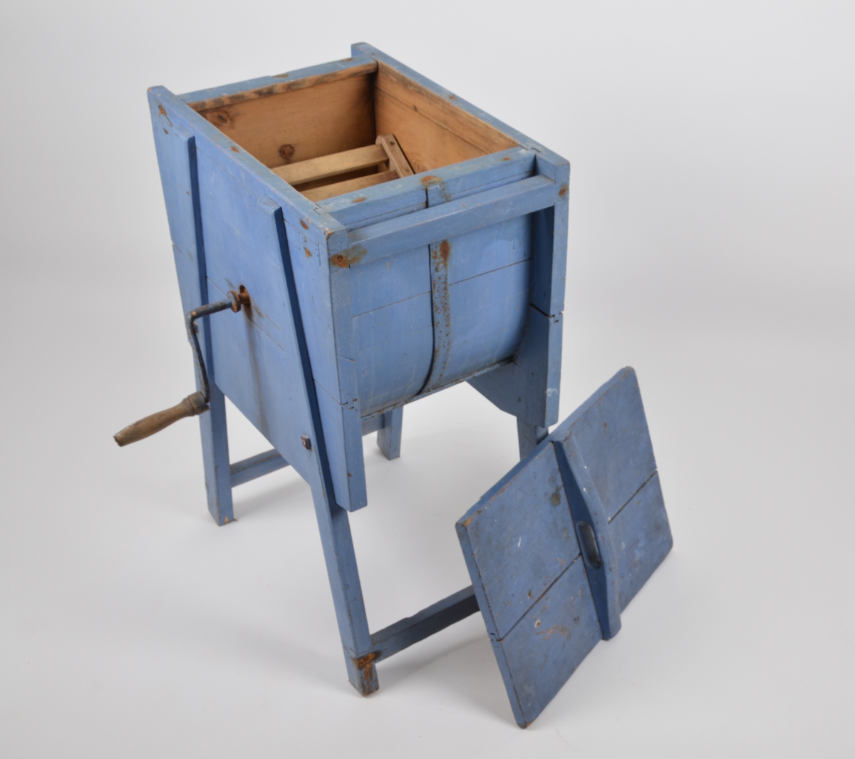 Vaskemaskin for tøyvask. Manuell med håndsveiv. Består av 2 deler, trommel og lokk. Laget av tre, malt blå.