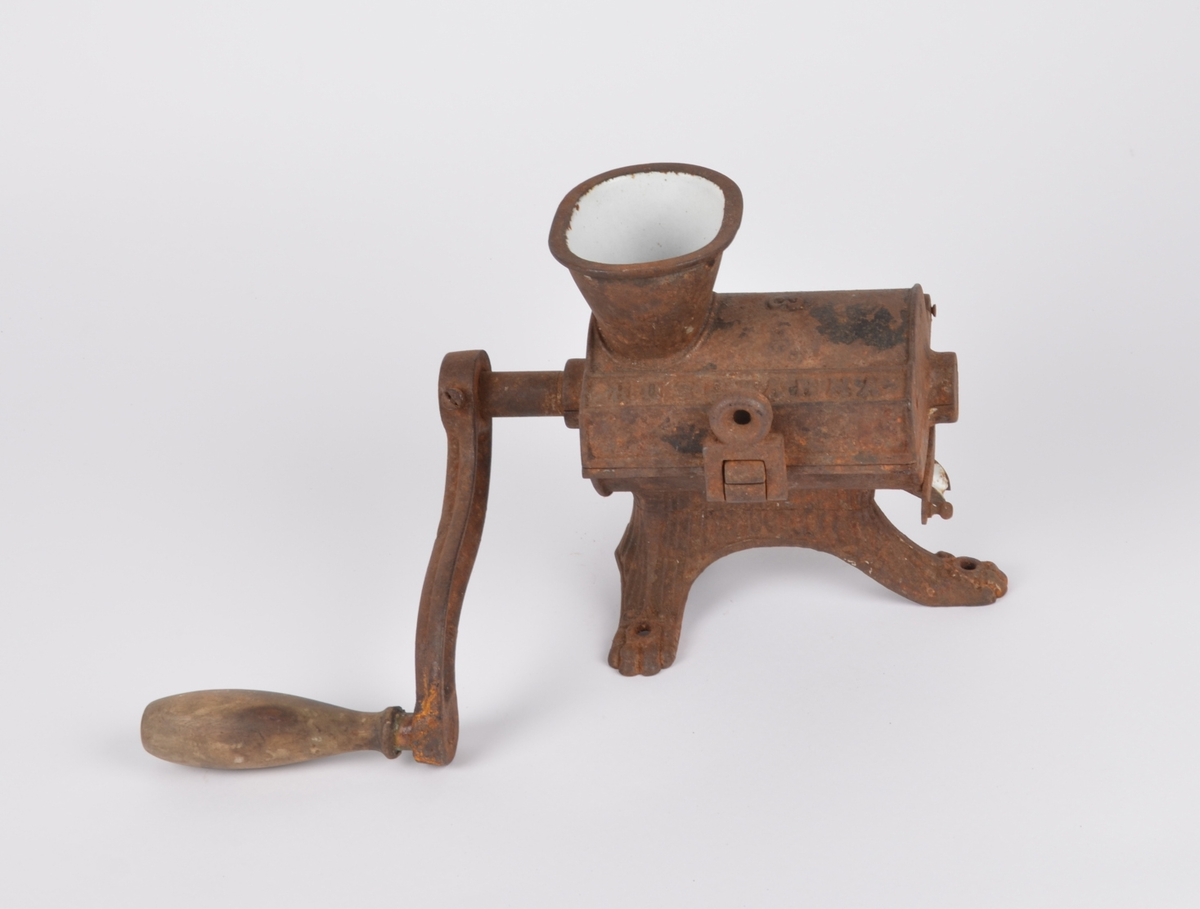 Bærkvern av metall til å festes i bordflate. Kvernhus med tre føtter med hull til skruefeste i bord. Hengslet lokk med trakt og lås, hengslepinner byttet ut med bøyde spiker. Innvendig emaljert. Løs kvern av metall skruddfast i sveiv av metall med trehåndtak.