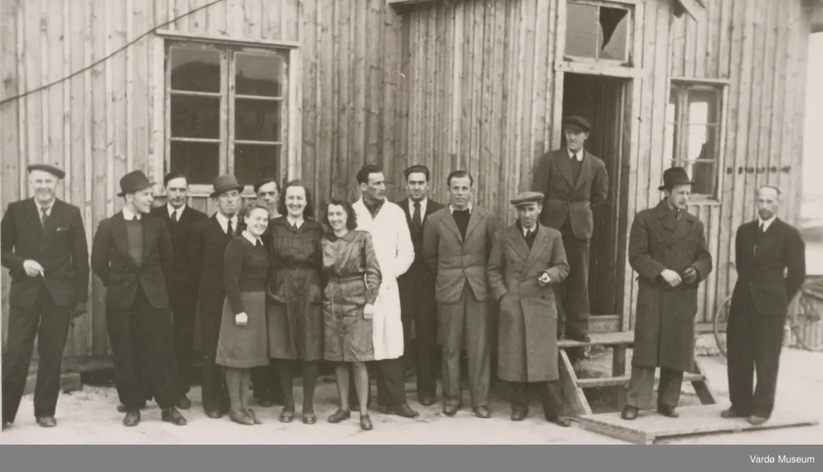 Gruppe personer utenfor gjenreisingsbrakke i Vardø, 1946