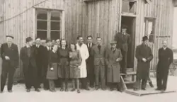 Gruppe personer utenfor gjenreisingsbrakke i Vardø, 1946
