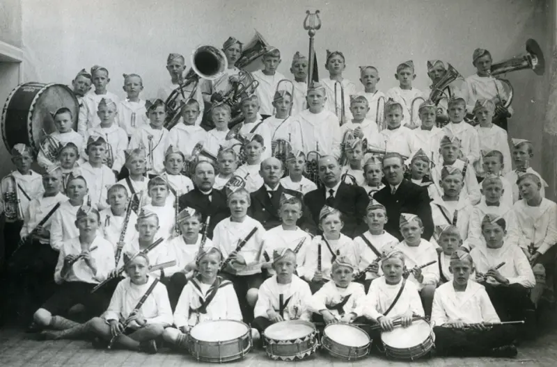 Tønsberg Guttemusikkorps fotografert 17. mai 1931. Dirigent Lie sitter i 3. rekke, som nr. 2 fra venstre av de voksne.