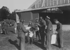Ordergivning inför flygning vid arméspaningskurs på Malmen, cirka 1934.
9 militärer samlade framför hangar 81 på F 3 Malmen.

Text vid foto: 