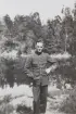 Porträttfotografi av löjtnanten och militäre flygaren Nils Olof Svensson (senare Sefeldt) ståendes framför en sjö, sommaren 1935.

Text vid foto: 