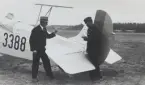 Två män i arbete vid stjärtpartiet på flygplan S 6 Fokker nr 3388, på ett flygfält omkring 1935-1973. Till vänster Bernhard Jernberg, flottiljfotograf på F 3, till höger militär flygaren Nils Olof Svensson (senare Sefeldt).

Text vid foto: 