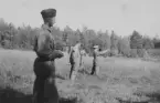 Militärer utöver pistolskjutning omkring 1935-1937. Fyra män på ett fält. Vy från sidan.

Text vid foto: 