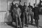 Gruppfotografi av sex militära flygare ståendes vid en husvägg, omkring 1935. Andra från vänster är Nils Olof Svensson (senare Sefeldt).

Text vid foto: 