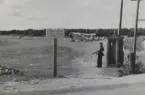 Karlsborgs flygfält med flygplan S 6 Fokker uppställda, omkring 1934-1937. I förgrunden syns vaktkur med en militär vakt med k-pist.

Text vid foto: 