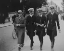 Tre militära flygare och en civilklädd man går på en gata i Örebro, omkring 1935. Andra från vänster är Nils Olof Svensson (senare Sefeldt).

Text vid foto: 