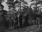 Fälttävlan under militär utbildning, cirka 1934. Tre militärer studerar kartor och en militär tittar i kikare. På en berghäll i terräng.

Text vid foto: 