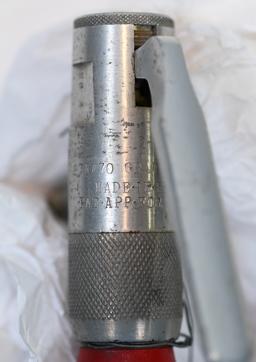 Brandsläckare i röd metall, med handtag och väggfäste, modell Graviner MK.27H. På föremålets framsida stor det information om tillverkaren och modellen och på baksidan användning och påfyllningsinformation, på engelska. Modell avsedd för användning med vatten. Föremålet fylldes på sist den 21 september 1955 i Sverige. Total vikt med laddning 1,3 kg.
