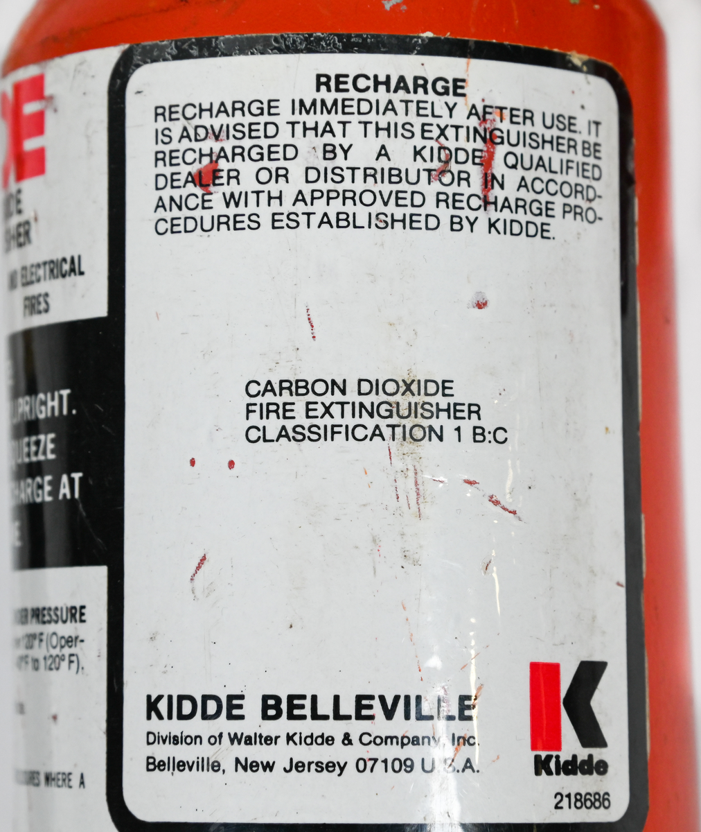 Kolsyresläckare. rödmålad, i metall med vridbar slang och aktiveringsknapp, modell 2TA. Tillverkad av Kidde i Belleville, New Jersey och använt av Linjeflyg. Första inspektionsdatum är 1975 och sista är 1985-10-04. Total vikt ifylld: 3395 gr.