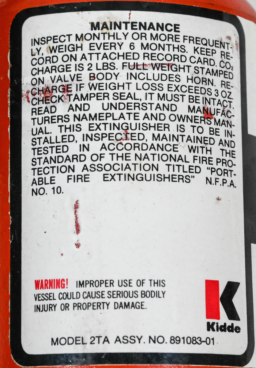 Kolsyresläckare. rödmålad, i metall med vridbar slang och aktiveringsknapp, modell 2TA. Tillverkad av Kidde i Belleville, New Jersey och använt av Linjeflyg. Första inspektionsdatum är 1975 och sista är 1985-10-04. Total vikt ifylld: 3395 gr.