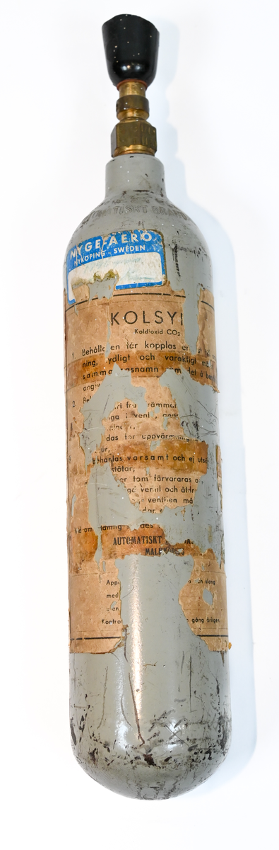 Kolsyreflaska i silverfärgad metall, förmodligen ansett som en del av en brandsläckare system. Flaskan är märkt som tillverkad av De Förenade Kolsyrefabrikernas AB 1/3/1952 och med sista inspektion av Swedish Airworks LTD 27/02/1974. På sidan finns det instruktion för hantering av föremålet som gasflaska på ena sidan och som brandsläckare på andra sidan. Fylld vikt: 1.31 kg. Prägling som attesterat att flaskan fick inspektion 1958, 1965 och 1972.