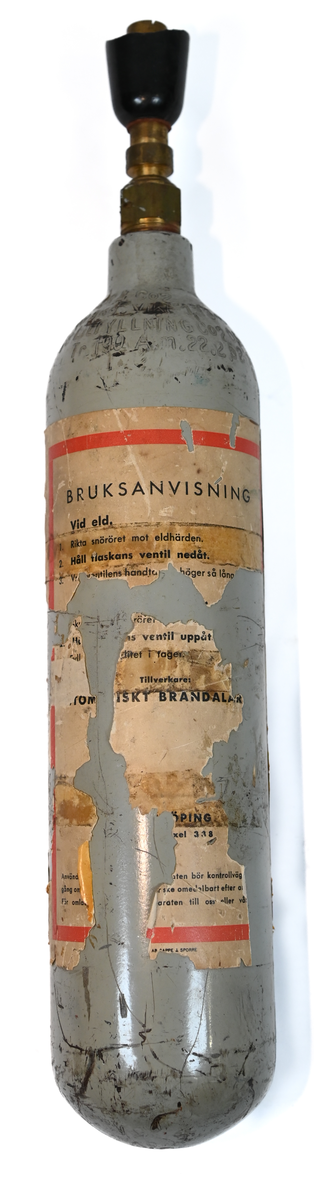 Kolsyreflaska i silverfärgad metall, förmodligen ansett som en del av en brandsläckare system. Flaskan är märkt som tillverkad av De Förenade Kolsyrefabrikernas AB 1/3/1952 och med sista inspektion av Swedish Airworks LTD 27/02/1974. På sidan finns det instruktion för hantering av föremålet som gasflaska på ena sidan och som brandsläckare på andra sidan. Fylld vikt: 1.31 kg. Prägling som attesterat att flaskan fick inspektion 1958, 1965 och 1972.