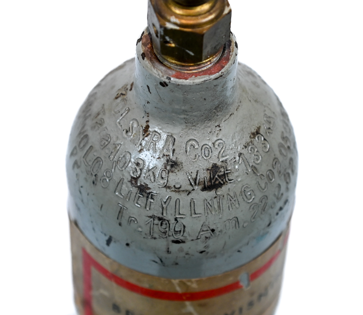 Kolsyreflaska i silverfärgad metall, förmodligen ansett som en del av en brandsläckare system. Flaskan är märkt som tillverkad av De Förenade Kolsyrefabrikernas AB 1/3/1952 och med sista inspektion av Swedish Airworks LTD 27/02/1974. På sidan finns det instruktion för hantering av föremålet som gasflaska på ena sidan och som brandsläckare på andra sidan. Fylld vikt: 1.31 kg. Prägling som attesterat att flaskan fick inspektion 1958, 1965 och 1972.