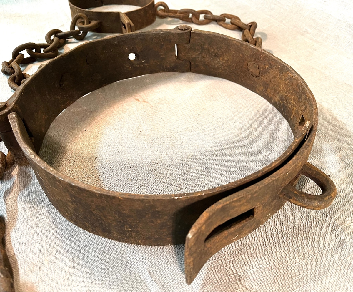 Svært kraftig fangejern bestående av halsring og midjejern. Halsringen er hengslet og festet tilmidjejernet med to lenker. Lenkene har 11 og 13 ledd. Midjejernet er tredelt, har to hengsler, og endestykker, det ene med tre hull, det andre med tre kramper, så jernet kan justeres etter fangens midjemål. Fra livringens bakside går en lenke på 25 ledd, for feste i vegg e.l.