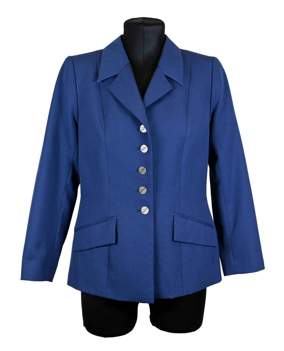 Kavaj i mörklbå ull- och polysterblandning till ämbetsdräkt för kvinnlig personal vid Luftfartsverket. Fodret är gjort i mörkblå polyester. Kavajen har två framfickor med lock som fortfarande är igensydda samt en innerficka vänster sida som stängs med plastknapp. Kavajen stängs med metallknappar med Luftfartsverkets logga i relief. 

På insidan ovanför innerfickan sitter en lapp med Luftfartsverkets logga samt information om tillverkare och designer. I anslutnings till den sitter en mindre lapp med storleksangivelser. Kavajen producerad av Confetti och designad av Morgan i storlek C42. På insidan i ena sidosömmen sitter ytterligare en lapp med tvättanvisningar och information om material och tillverkningsort. Kavajan är tillverkad i Estland. I denna lapp sitter en extra metallknapp samt en fasthäftad papperslapp med numret "8632" i tryck och "3/10" påskrivet i blått bläck.