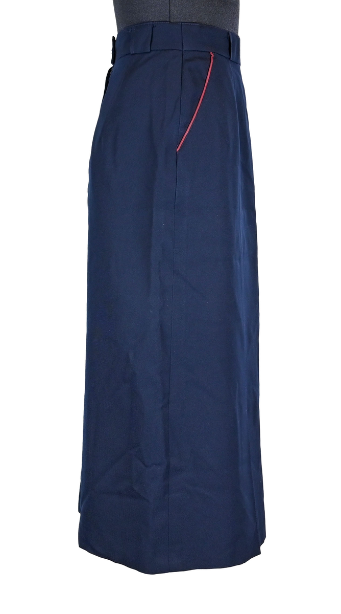 Kjol för flygbolagspersonal på Linjeflyg. Mörkblå snäv modell med slitsar och veck för vidd nertill. Med vinröda passpoaler på fickornas kanter. Märkt ”Linjeflyg”.