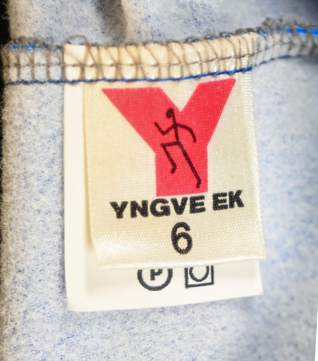 Byxa till träningsoverall. Plagget är gjort av tyg i polyamid och triacetat. Byxan är blå med smala bårder i gult tyg längs med benens yttersida. Inuti finns foder i vitt tyg. På vardera sida i fram finns två byxfickor som sluts med blå dragkedja i metall och plast. I midjan sitter ett resårband. 

Enligt en lapp fastsydd i sömmen bak på byxans insida är plagget producerat av Yngve Ek, Höör Sweden. Där finns även två identiska lappar som anger att byxan är gjord av 45% polyamid och 55% triacetat. Där finns även tvätthänvisningar.

Byxan är en del av en tävlingsoverall för svenska landslaget i hängflygning tillsammans med jacka AFS2508.