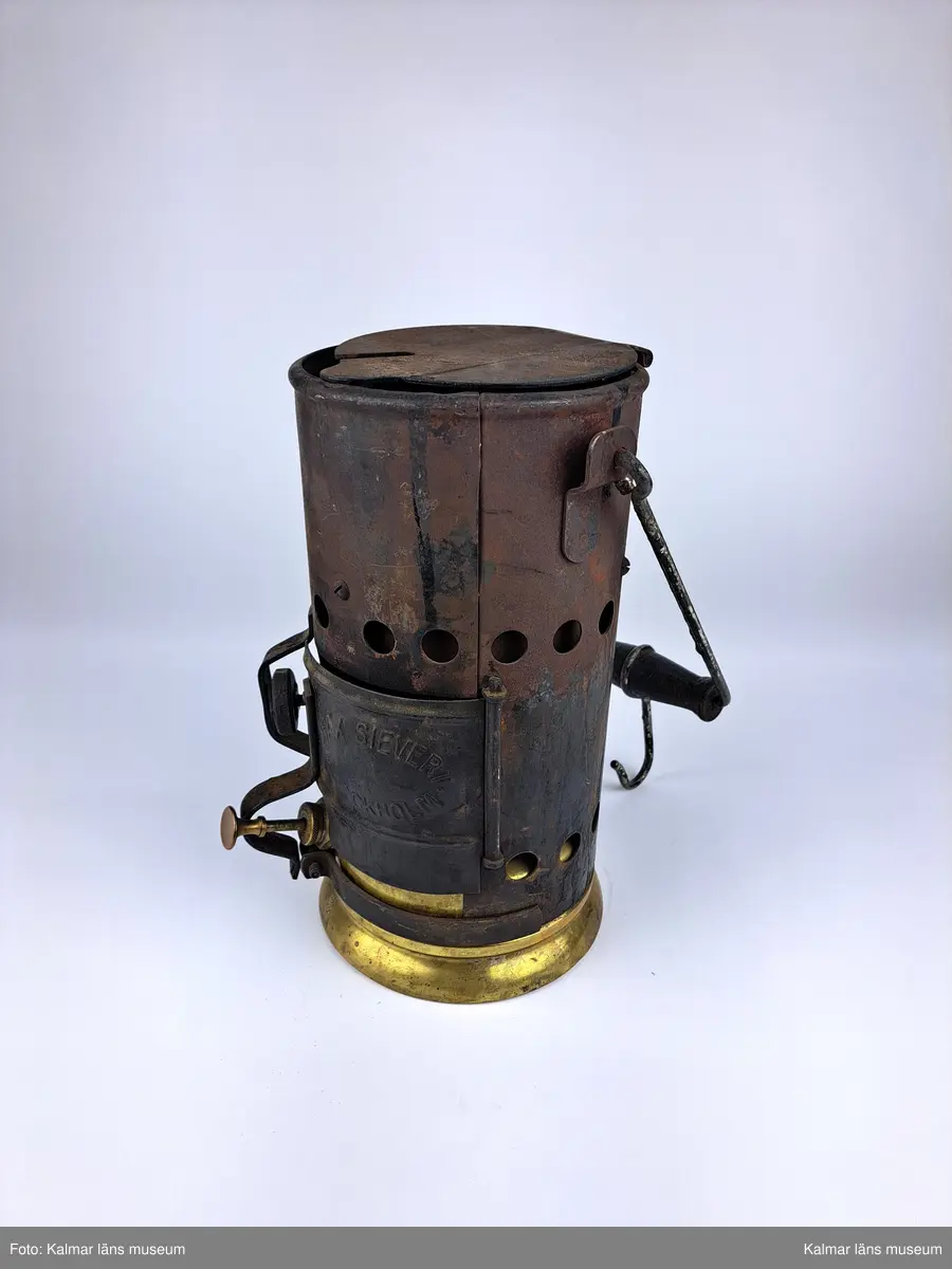KLM 46808:9:1-2. :1. Smältugn, lödugn, med smältdegel. Cylindrisk smältugn av plåt med lock, handtag och lucka på framsidan. På luckan tillverkarstämpel: MAX SIEVERT STOCKHOLM. Underdel av mässing. På handtaget en krok för upphängning. Inuti en uttagbar insats av metall. 
:2. Smältdegel av gjutjärn med rund form och handtag. På handtaget en skruvögla för upphängning. På degelns kanter tillverkarstämpel: MAX SIEVERT STOCKHOLM SWEDEN. Har troligtvis använts för smältning av exempelvis metall för lagning av elkablar och eventuellt annat på järnvägsspåret.