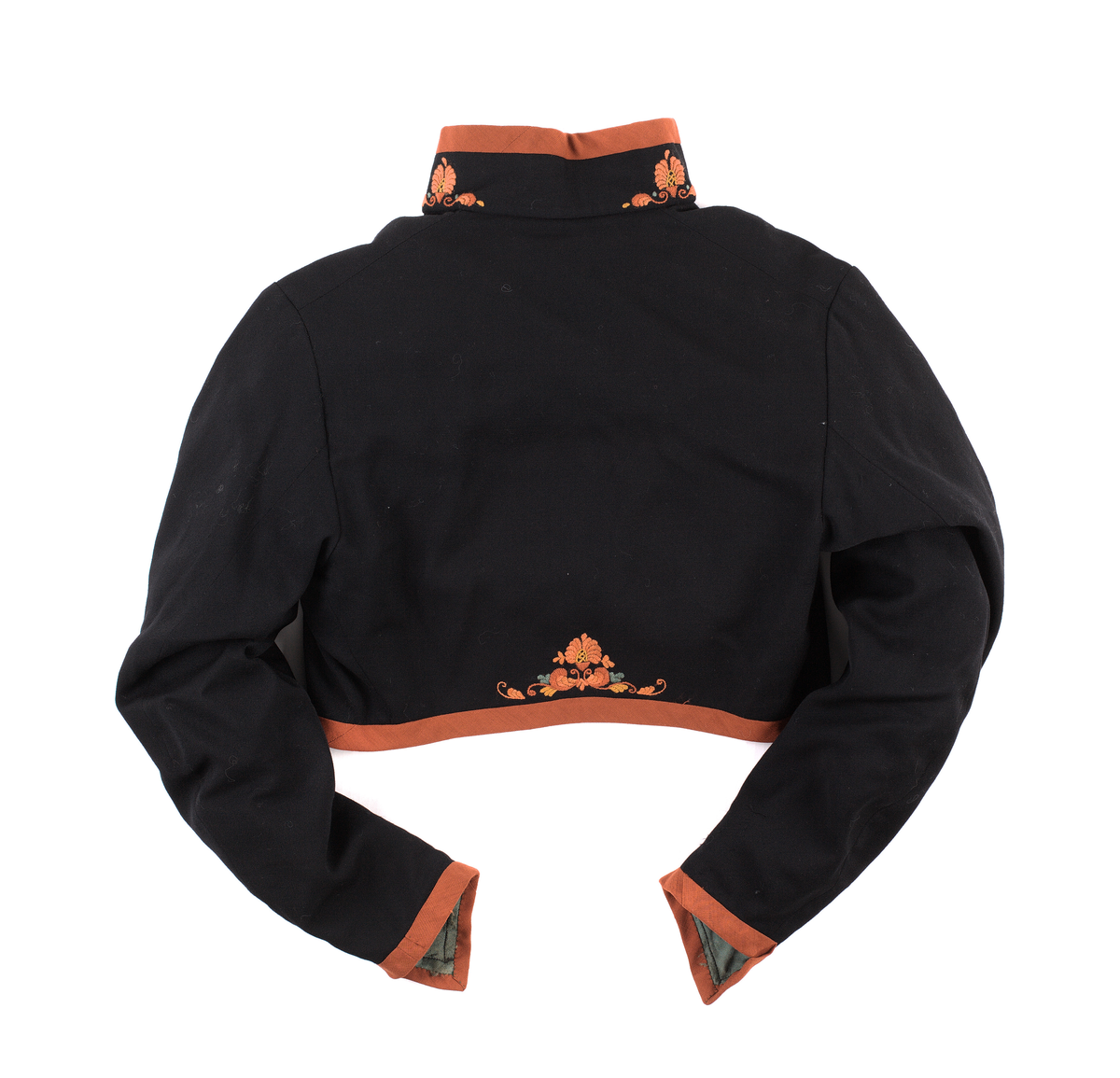 Trøye til Vest-Telemark bunad i ullstoff med rosesaum i jordfargar. Trøya har eit kuftespenne i filigramsrbeid øverst i opninga framme. Ståkrage og splittar ved handledda.