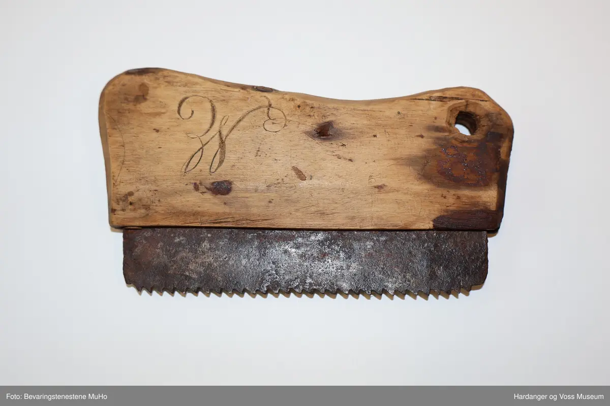Lita handsag med blad av stål og rektangulært handtak av tre med sivng-kant.