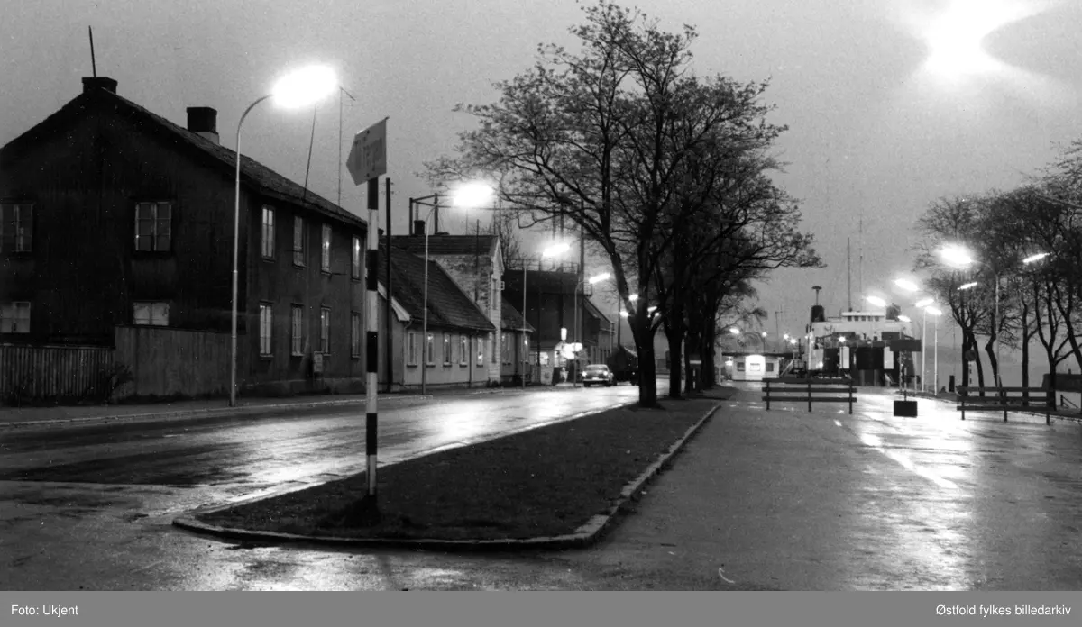 Østre Kanalgate i Moss mot sør, ca. 1980. Nattbilde. I bakgrunnen Bastøferga  (Moss - Horten) og fergekaien.
Østre Kanalgate 7 (2 etasjer), 5 (en etasje (pluss 2), 3 (n etasje (Gabrielsen)), 1 (Moss Gassverk).