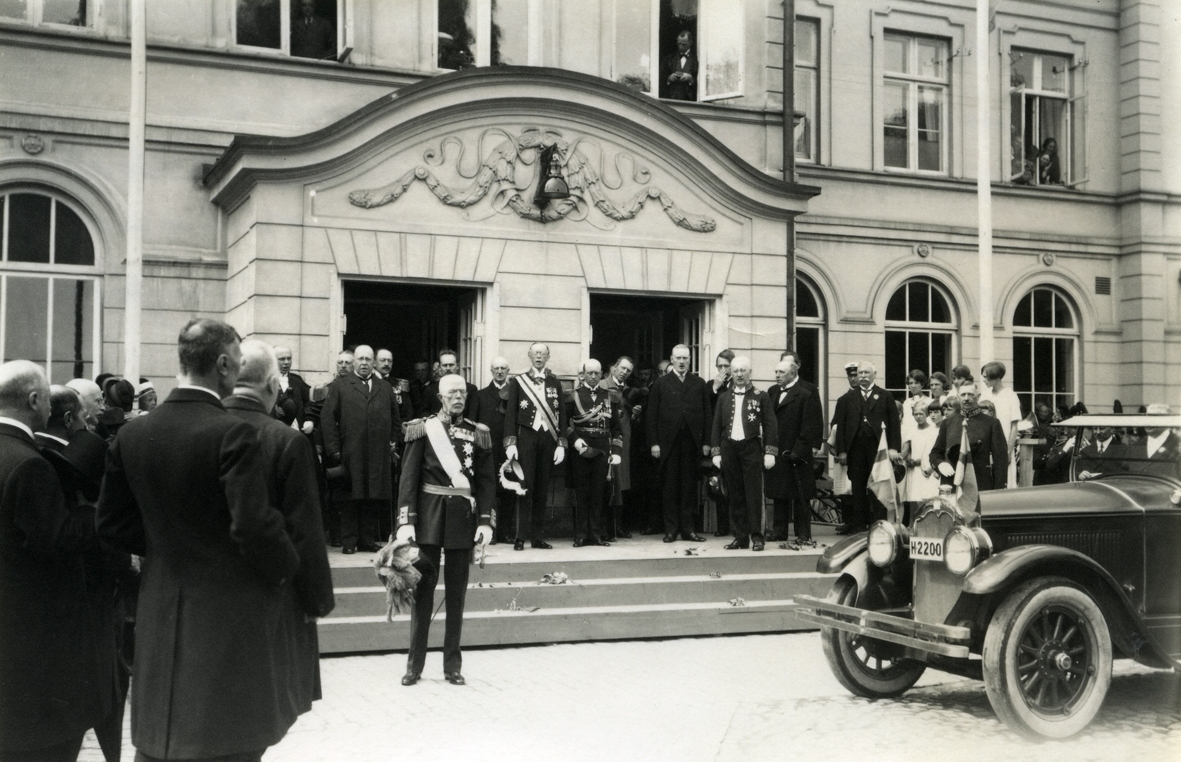 Gustav V anländer. Bilen en Buick 1924-1925 Master model tillhör droskägare August Lindh Kalmar. Landshövding John Falk vid höger dörr i uniform.