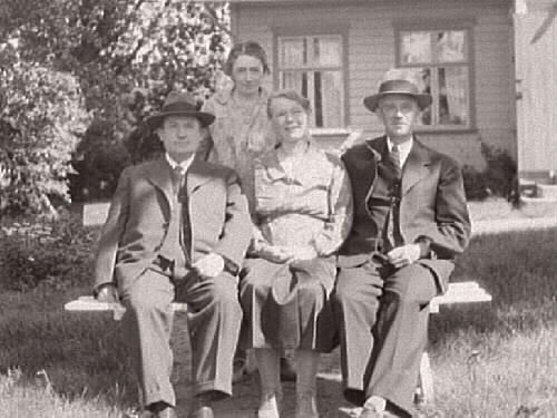 Fotografen Gerda Winqvist står bakom bänken där hennes bror Johan sitter till höger med sin fru Amelie och till vänster Fredrik Winqvist, halvbror till Johan och Gerda. Fotot taget på huset vid Fastarpsvägen i Tvååker sa 1930.