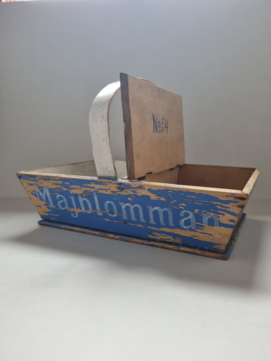 Korg i trä för försäljning av majblommor. 1913-14. Blå och vitmålad. Skänkt av A. Forslund, Göteborg
