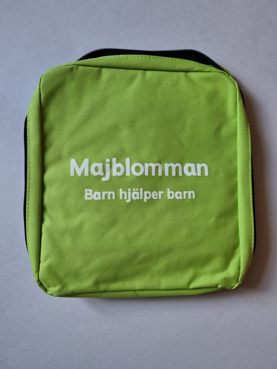 Försäljarväska för majblommor. Grön i nylon. Med majblommor, försäljarkit. Från 2014. Med bärsele
