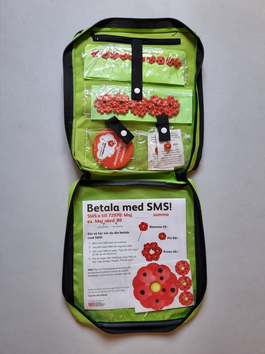 Försäljarväska för majblommor. Grön i nylon. Från 2017. Med försäljarkit av majlommor i.