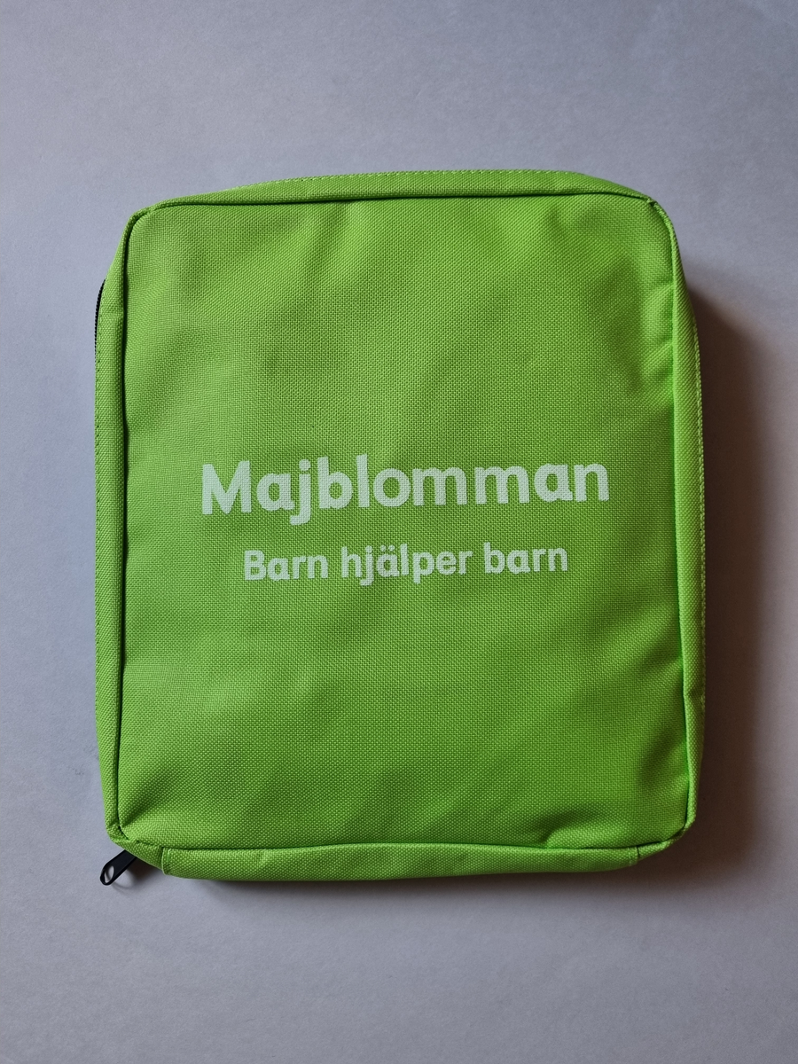 Försäljarväska för majblommor. Grön i nylon. Från 2017. Med försäljarkit av majlommor i.