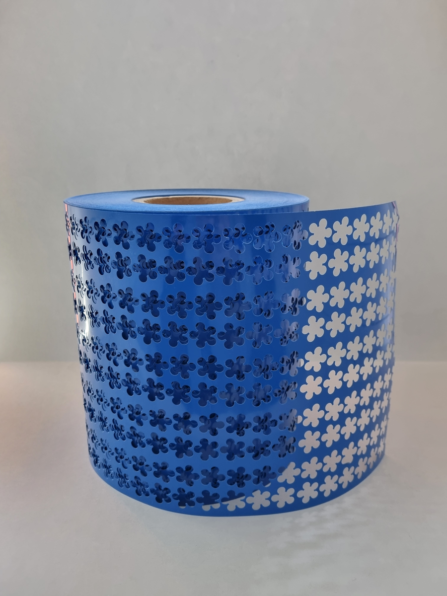 Rulle som suttit i majblommemaskin och är en restprodukt av majblommetillverkning. Blå.  Under en period såldes bordslöpare av detta material.